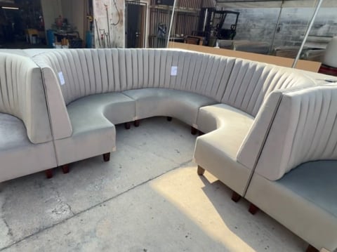 Modern curved cream-colored modular sofa with vertical ribbed texture displayed in a showroom